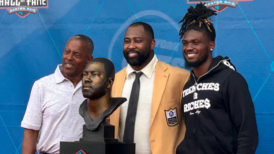 M.J. Devonshire, right, poses with Tony Dorsett, left, and Darrelle Revis during Revis' enshrinement into the Pro Football Hall of Fame last year in Canton, Ohio.